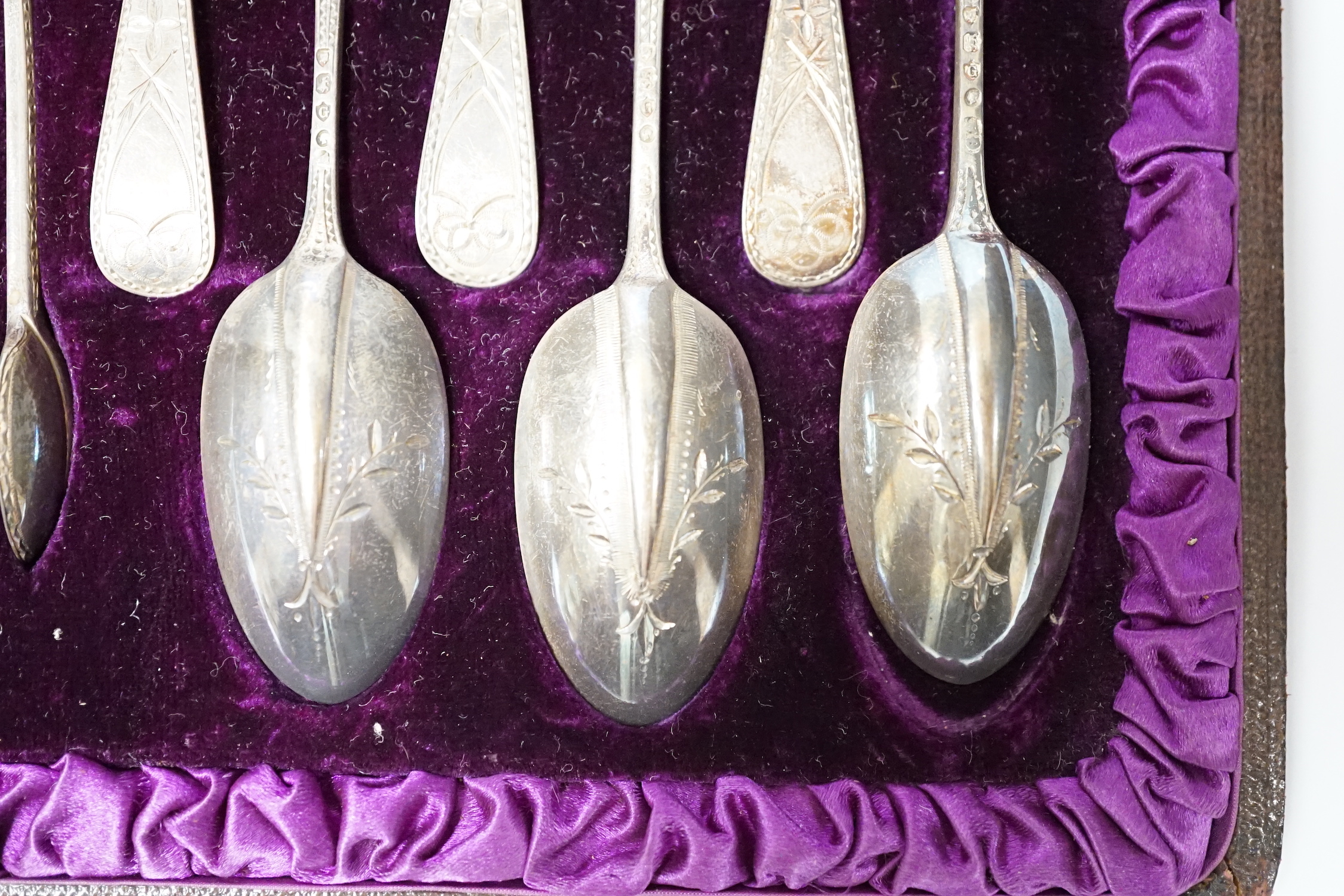 A cased set of twelve Victorian engraved silver rat tail pattern teaspoons with sugar tongs, George Adams, London, 1882.